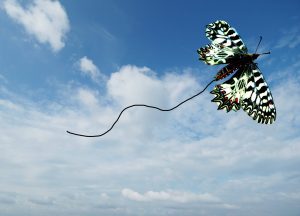 Umelecká fotokoláž motýľa na modrej oblohe, symbolizujúca oslobodenie duše a vnútornú slobodu.